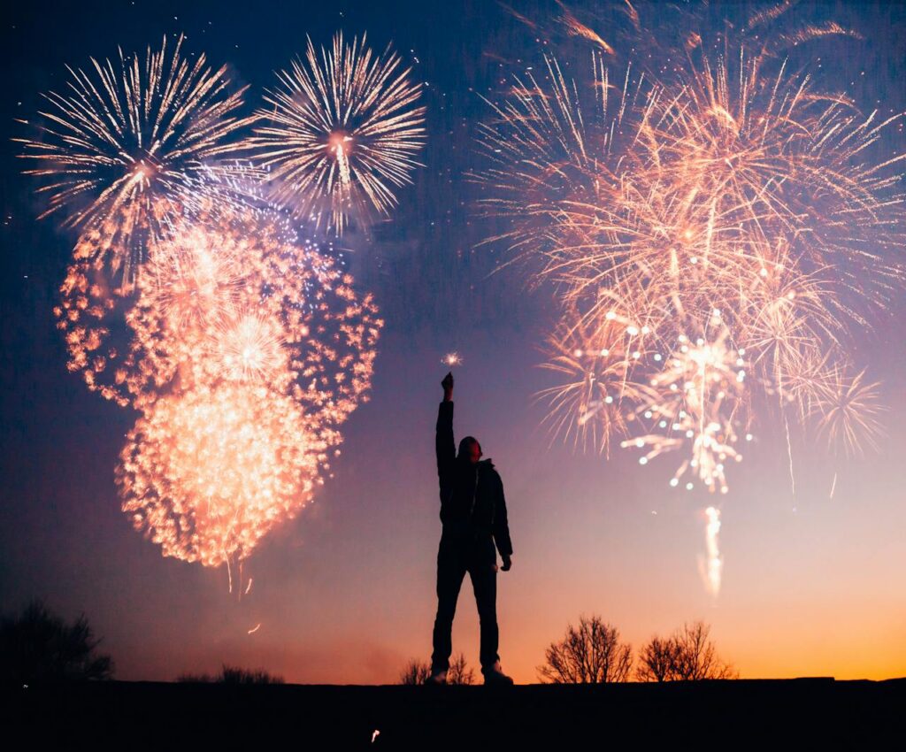 pexels photo 769525 A person celebrates under vibrant fireworks in the evening sky in Kragujevac, Serbia.